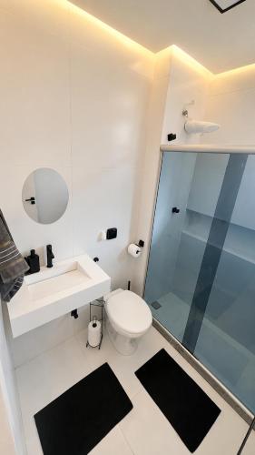 a bathroom with a toilet and a sink and a shower at Apartamento com Lareira a 5 Min da Feirinha do Alto - Piscina e Sauna in Teresópolis
