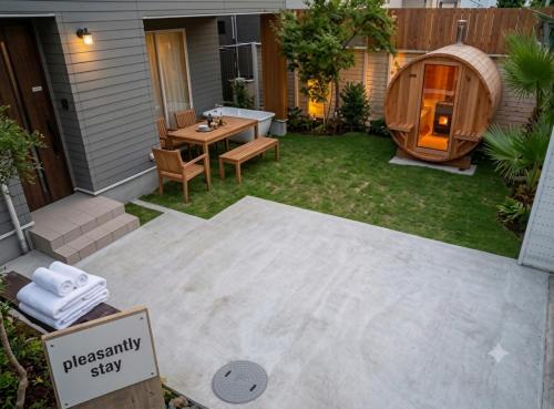 a backyard with a wooden table and a circular sauna at 2022新築pleasant stay 海徒歩3分BBQ焚火 in Ichinomiya