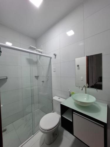 a bathroom with a toilet and a sink and a shower at Pousada Flor de Sal in Macau