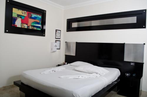 a white bed in a room with a tv at Torettos in Yumbo