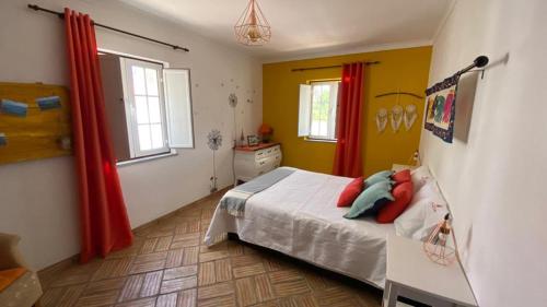 a bedroom with a bed and a red curtain at Tapada Poço das Canas in Redondo
