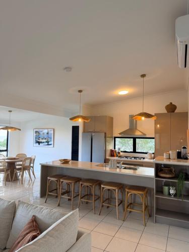 a kitchen and living room with a large table and chairs at The Dune House in Tangalooma