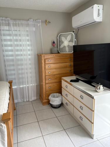 a bedroom with a bed and a dresser with a fan at Oasis of the forest in Brandon