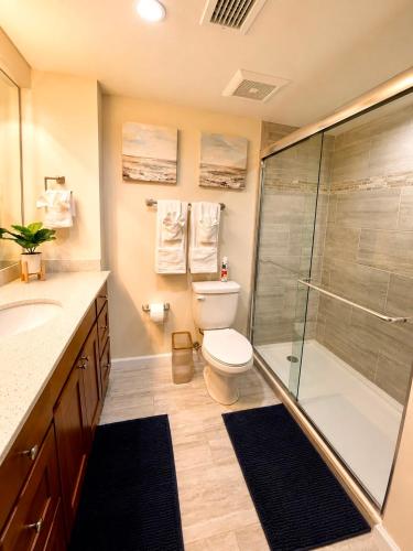 a bathroom with a toilet and a glass shower at The Caloosa Retreat in Fort Myers