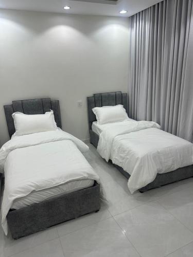 two beds sitting next to each other in a room at شقة غرفتين وصالة in Musaylah
