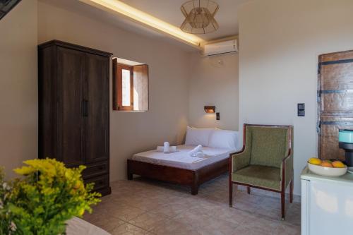 a bedroom with a bed and a chair in a room at Aspalathos guest rooms in Vathia
