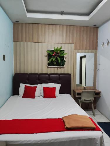 a bedroom with a large bed with red pillows at Angs residence in Surabaya