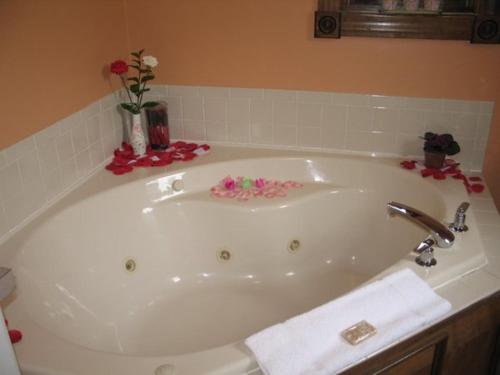 El baño incluye una bañera blanca con flores. en Spruce Hill Inn & Cottages, en Mansfield