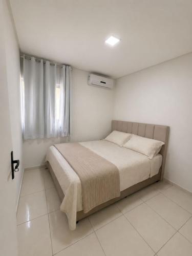 a bedroom with a bed in a white room at Apartamento em Caruaru 3 quartos completo in Caruaru