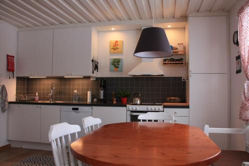 cocina con mesa de madera y armarios blancos en Puoltikasvaara 3 en Puoltikasvaara