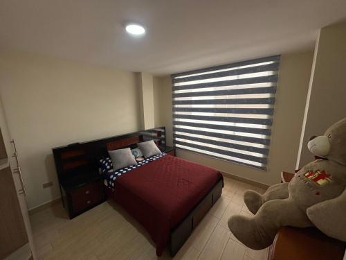 a bedroom with a red bed and a large window at Alojamiento in Ibarra