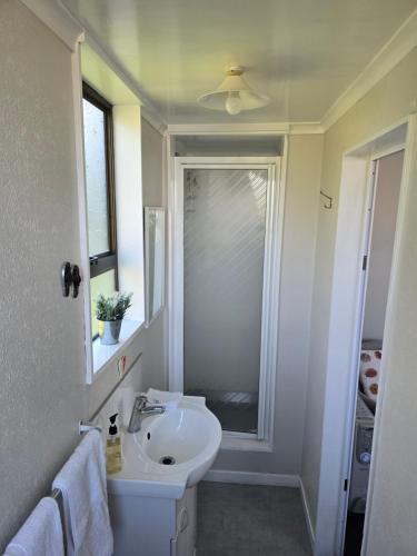 a white bathroom with a sink and a window at Quiet Boutique Generous Breakfast in Palmerston North