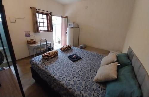 a living room with a bed and a couch at Kitnet - quarto - privativo in Itupeva