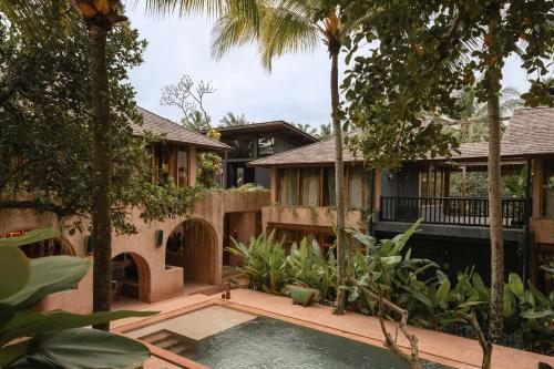 an external view of a house with a swimming pool and trees at Moon Gang Ubud in Ubud