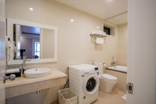 a bathroom with a washing machine and a sink at GM Hotel and Apartment in Hai Phong