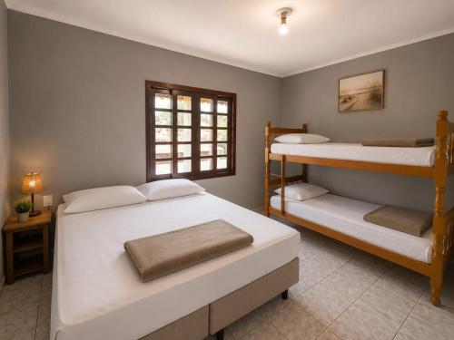 a bedroom with two bunk beds and a window at GH Pinheira in Palhoça