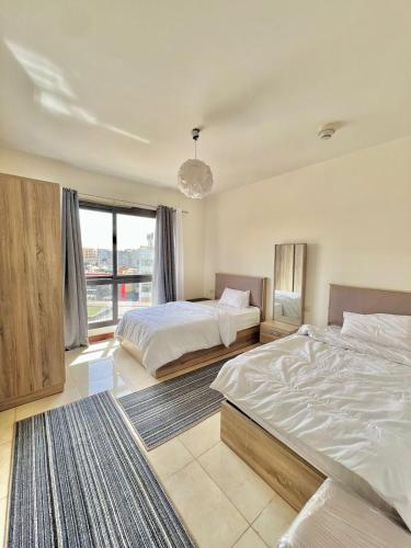 a bedroom with two beds and a large window at Unique duplex hotel apartment pool view in Cairo