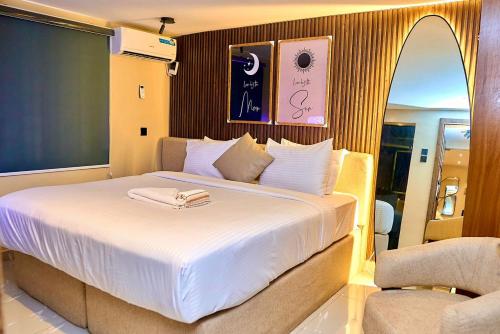 a bedroom with a large white bed with a towel on it at Luxembourg Apartment in Lagos