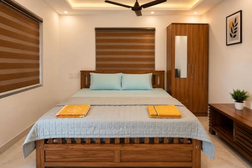 a bedroom with a bed with two towels on it at Nibras Villas in Varkala