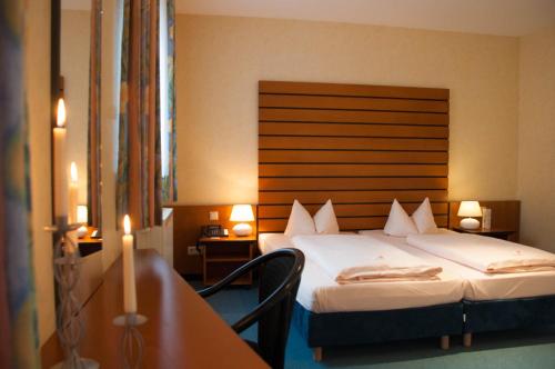 a hotel room with two beds and a table at Hotel Stadt Püttlingen in Püttlingen