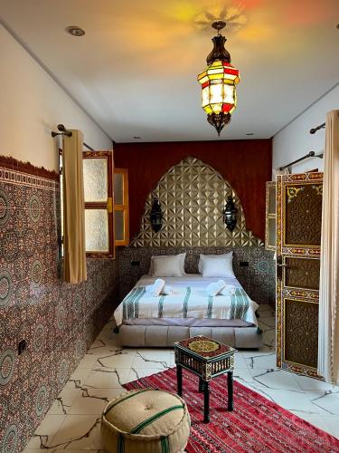 a bedroom with a bed and a chandelier at Riad Maison Eden in Rabat