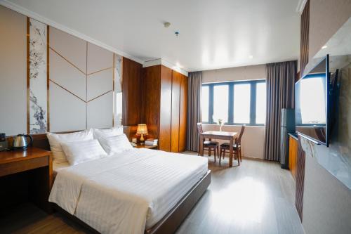 a hotel room with a bed and a table at GM Hotel and Apartment in Hai Phong