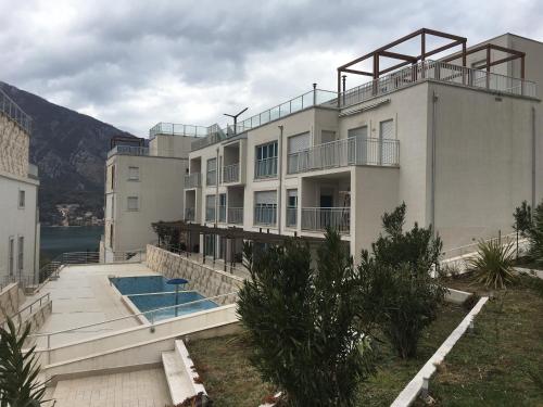 a large white building with a swimming pool at Buena Vista Apartments in Kotor