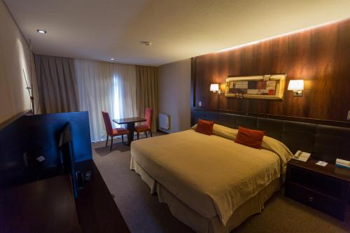 a hotel room with a bed and a table at Imago Hotel & Spa in El Calafate