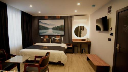 a hotel room with a bed and a table at Aerohub Grand Hotel in Arnavutköy