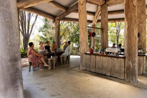 a group of people sitting at a bar in a building at Hidden Valley Cabins & Tours in Coolbie