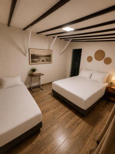 a room with two beds and a table in it at Flamingo Beach Pousada in Cabo Frio