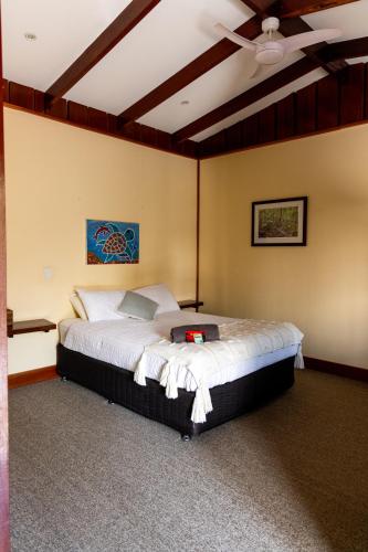 a bedroom with a bed with a ceiling fan at Hidden Valley Cabins & Tours in Coolbie
