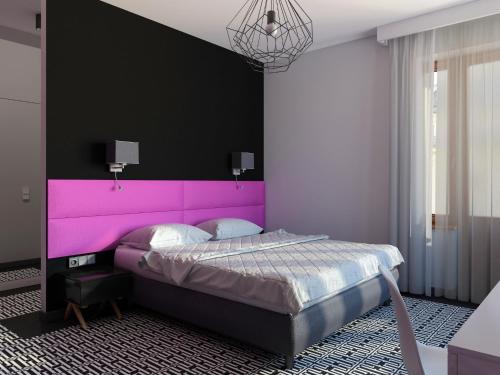 a bed with a pink headboard in a bedroom at Liv'Inn Aparthotel in Krakow