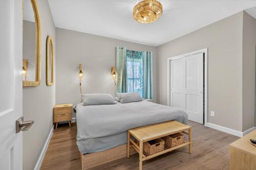 a bedroom with a bed and a table at Ninas Villas - Brand New Luxury Villas in Galveston