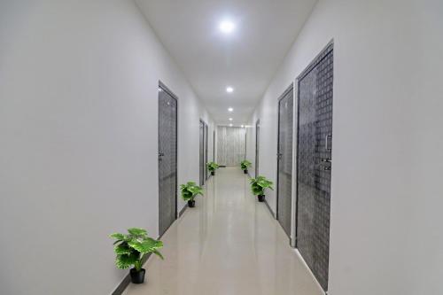 a corridor with potted plants in a hallway at OYO 93463 Alwal Residency in Hyderabad