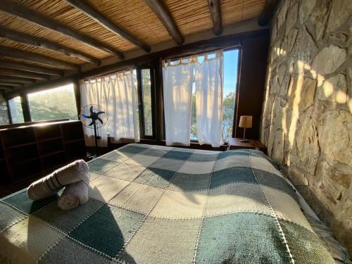 a bedroom with a large bed in a stone wall at Velas del Lago in Piedras Moradas