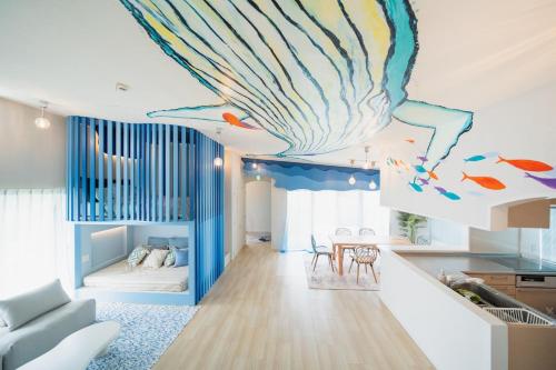 a living room with a large mural of a shell on the ceiling at The Mural Art House Bise in Motobu