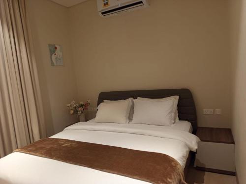 a bedroom with a large bed with white sheets and pillows at إطلالة هوانا in Ma‘mūrah