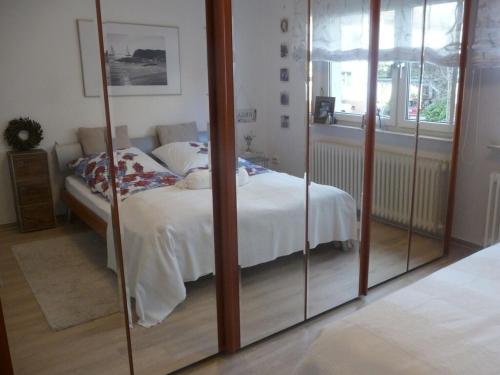 a bedroom with a bed and a glass closet at Trade fair and holiday accommodation in Oberursel