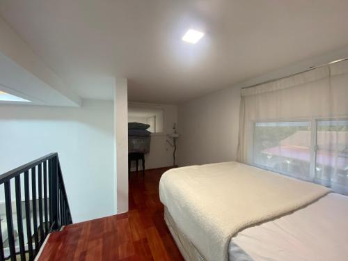 a bedroom with a white bed and a window at D'Alor Homestay in Pasir Mas