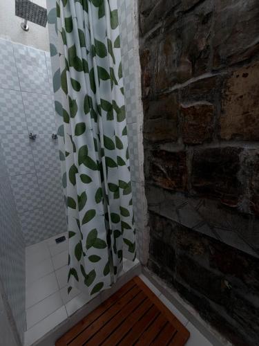 a shower with a shower curtain with leaves on it at Hotel Puerta de Jade in Ciudad Valles