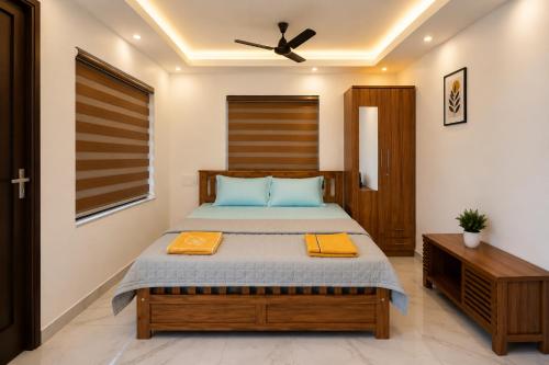 a bedroom with a bed and a ceiling fan at Nibras Villas in Varkala