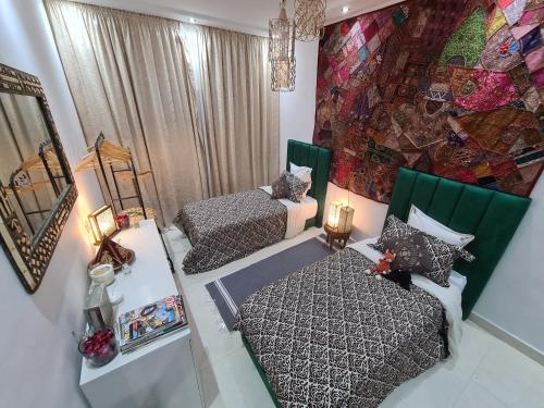 a small room with two beds and a mirror at DAR agafay in Lalla Takerkoust