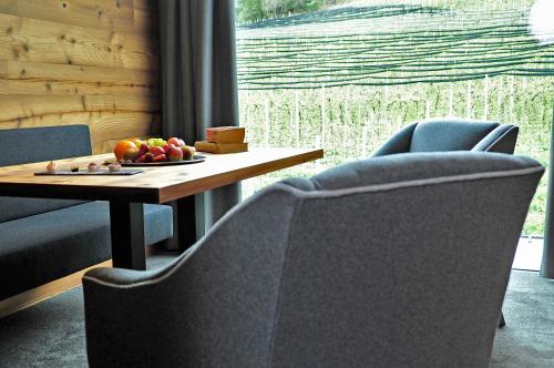 a table with a plate of fruit and two chairs at Hotel Restaurant Kirchsteiger in Vollan