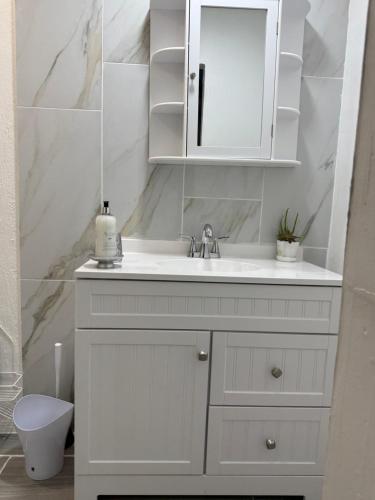 a white bathroom with a sink and a toilet at Serenity Garden Studio with Pool in Naples