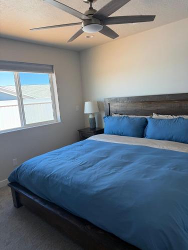 a bedroom with a blue bed with a ceiling fan at Desert view apartment in Page