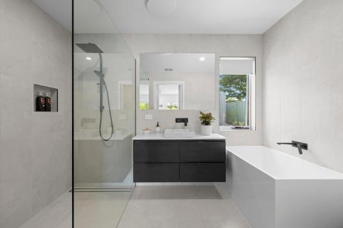 a white bathroom with a sink and a shower at Links Golf Retreat in Mansfield