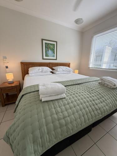 a bedroom with a large bed with towels on it at Melaleuca Resort in Palm Cove