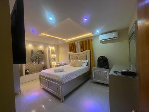 a bedroom with a bed in a room with purple lights at Apt cómodo a 6 minuto de megacentro in El Bonito