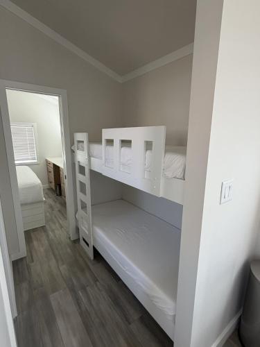 a white bedroom with two bunk beds in it at Roam America Horseshoe Bend in Page